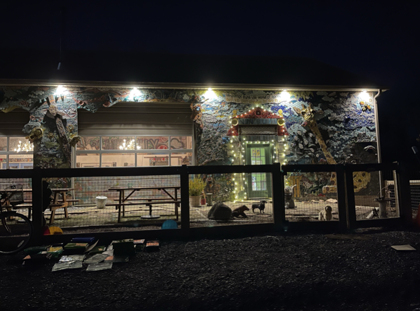 This is an image of the facade of the Bell Buckle Mosaic House lit up at night.