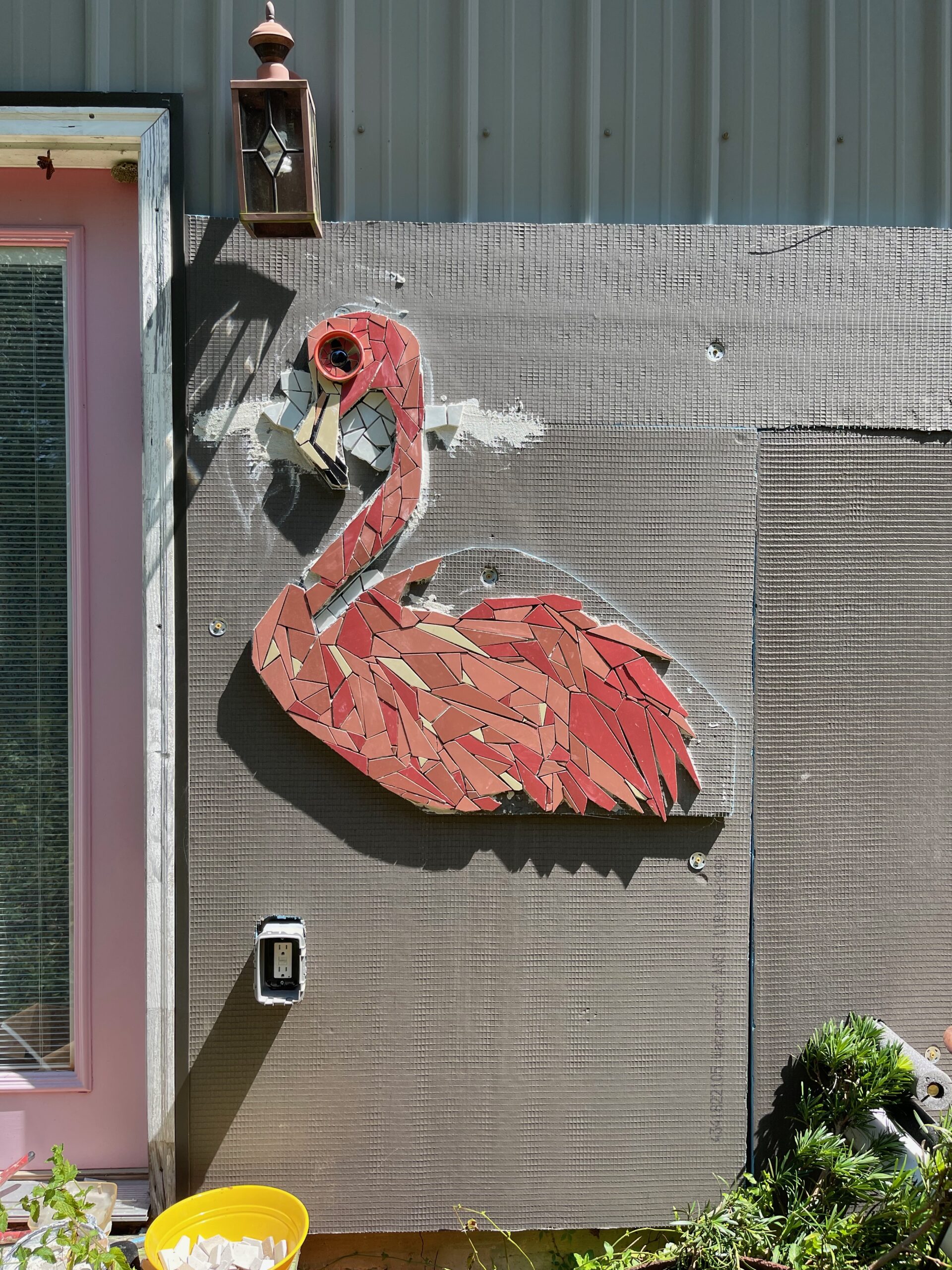 The image shows a mosaic flamingo in the process of being created.