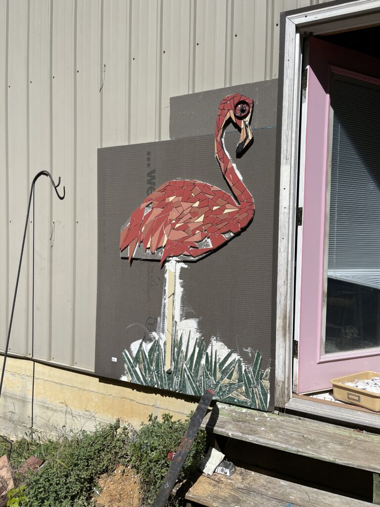 This image is a large mosaic flamingo standing in tall grass.