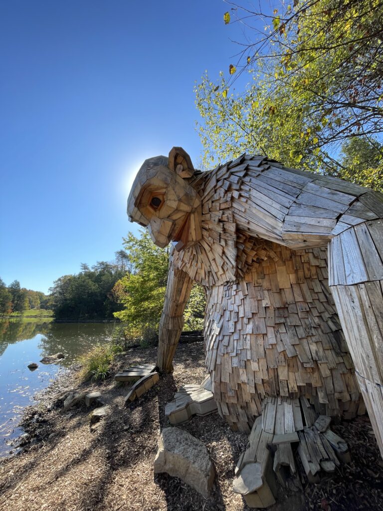 Little Nis, in profile as the sun rises overhead, one of Thomas Dambo's Forest Giants at the Bernheim Arboretum and Research Forest in Kentucky